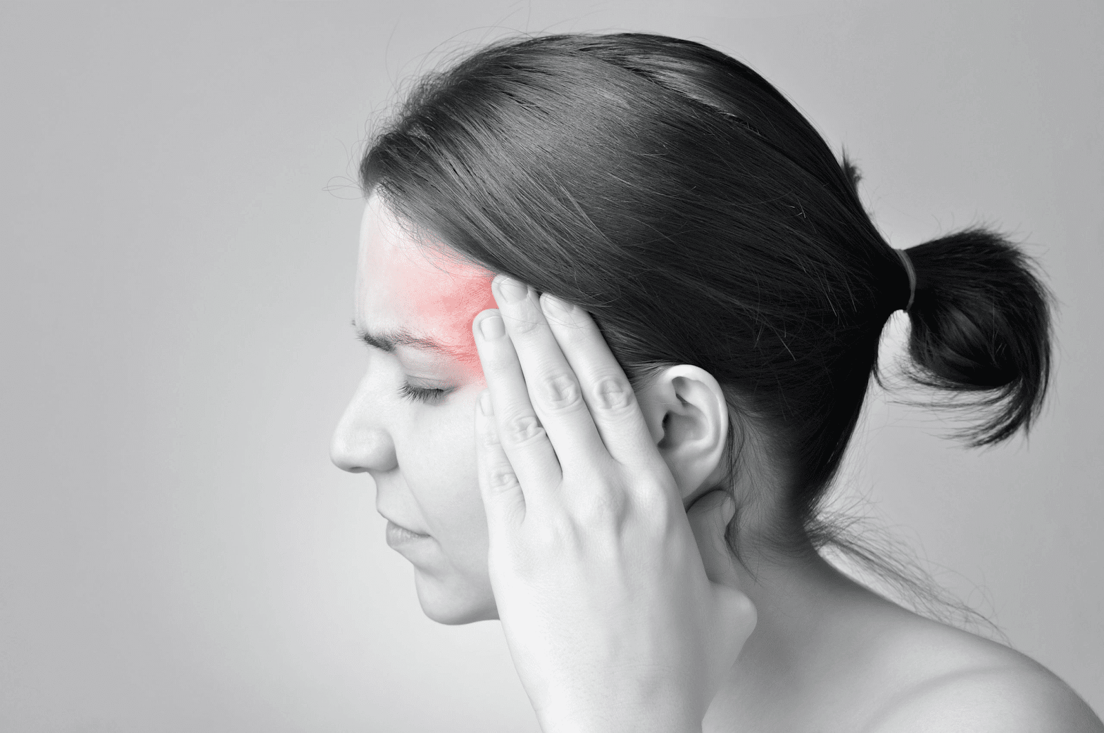 A black and white picture highlighting a woman's throbbing headache.