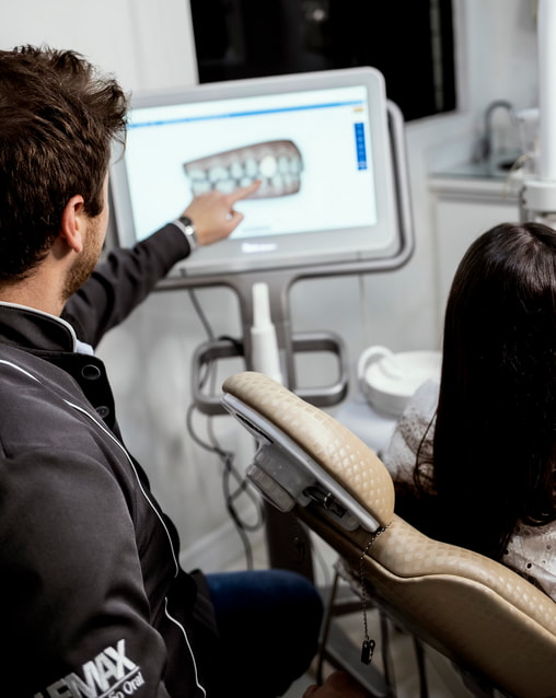 A dentist showing a patient a model of their teeth. 