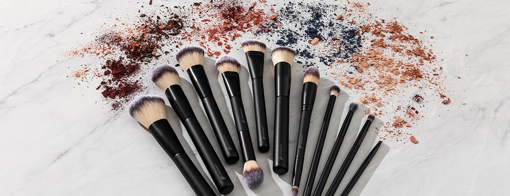 A collection of makeup brushes suitable for various skin types displayed on a white background. 