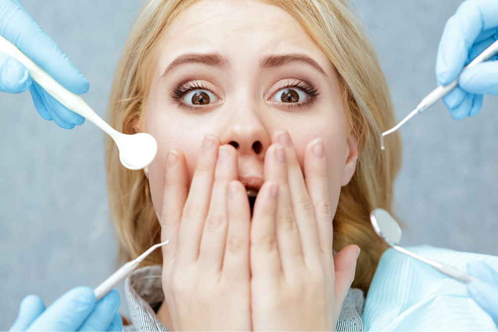 A woman examines her mouth while holding dental tools, focused on her dental health and hygiene.