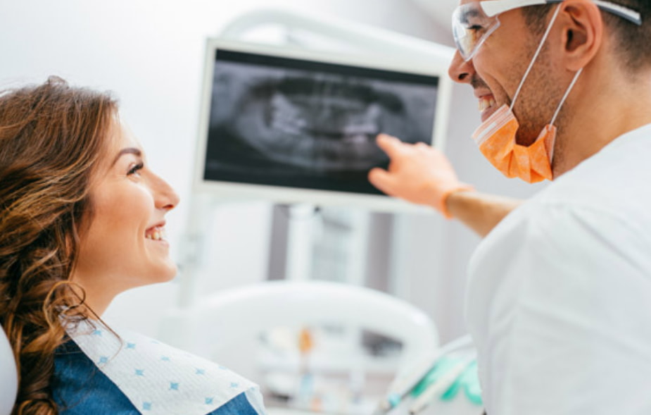 A man and woman smile while examining an X-ray together, showcasing a moment of shared interest and curiosity.