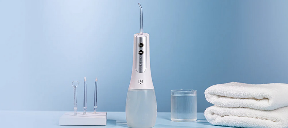 A toothbrush, toothpaste, and dental items arranged neatly on a blue surface. 