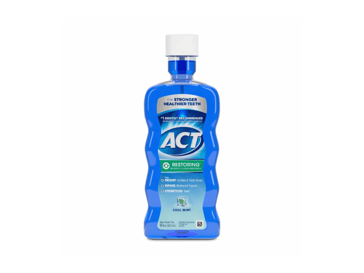 Bottle of ACT Restoring zero alcohol fluoride mouthwash in a blue container for cavity protection and enamel strengthening