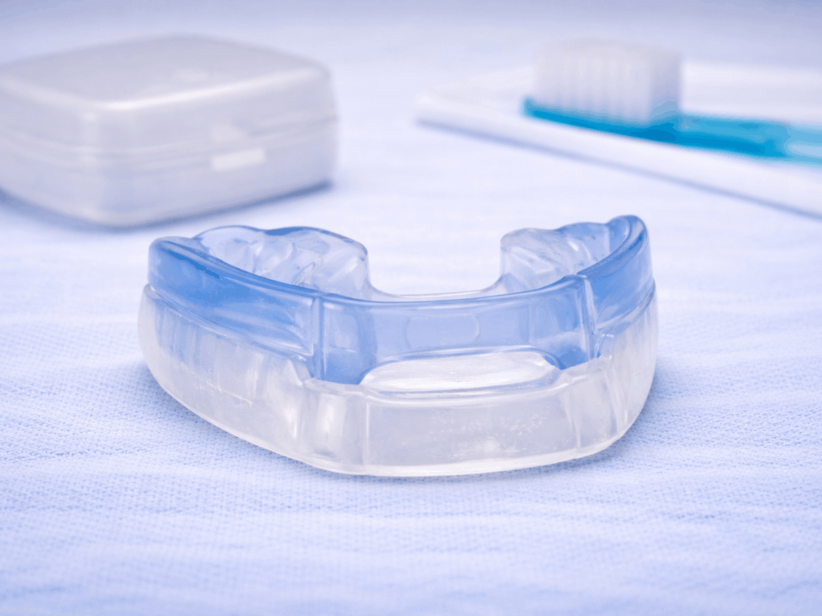 Clear custom dental night guard used to protect teeth from grinding and clenching during sleep.