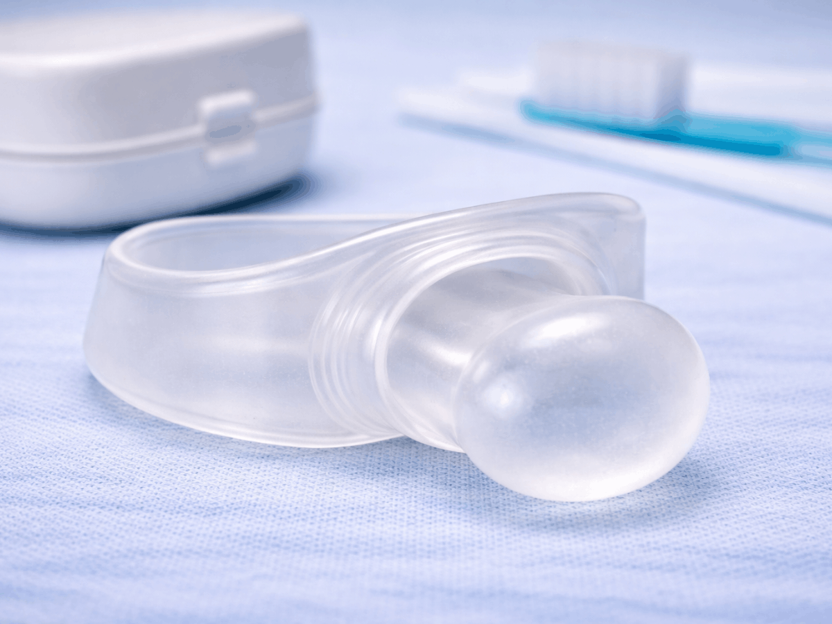 Custom clear oral appliance used to treat sleep apnea by repositioning the lower jaw and improving airflow during sleep.